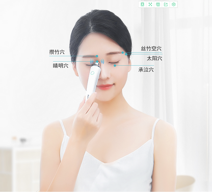 Woman using Aiyisheng Heated Bian Stone Eyes Massage Device on acupressure points around eyes.